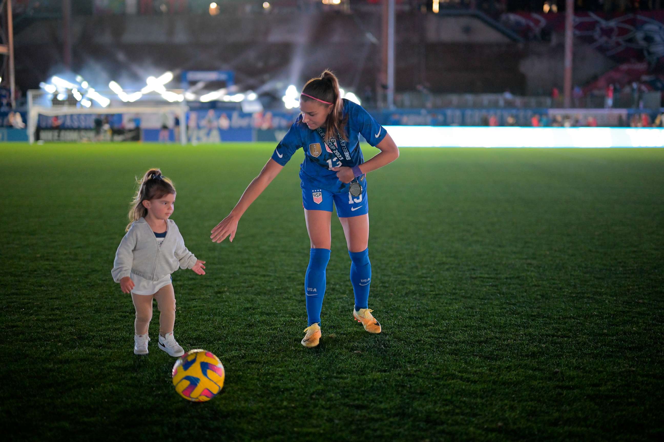 PHOTO: Alex Morgan #13 of the United States kicks a ball with her daughter Charlie after winning the SheBelieves Cup against Brazil at Toyota Stadium on Feb. 22, 2023 in Frisco, Texas.