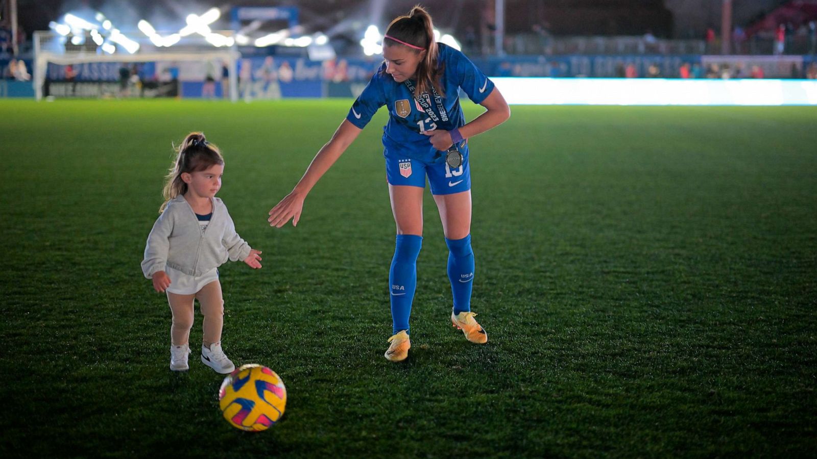 PHOTO: Alex Morgan #13 of the United States kicks a ball with her daughter Charlie after winning the SheBelieves Cup against Brazil at Toyota Stadium on Feb. 22, 2023 in Frisco, Texas.