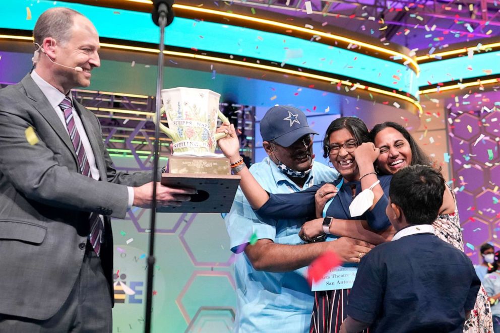 PHOTO: Harini Logan, 14, from San Antonio, Texas, celebrates winning the Scripps National Spelling Bee with her family, as Scripps CEO Adam Symson, left, presents the Scripps National Spelling Bee winning trophy, June 2, 2022, in Oxon Hill, Md. 