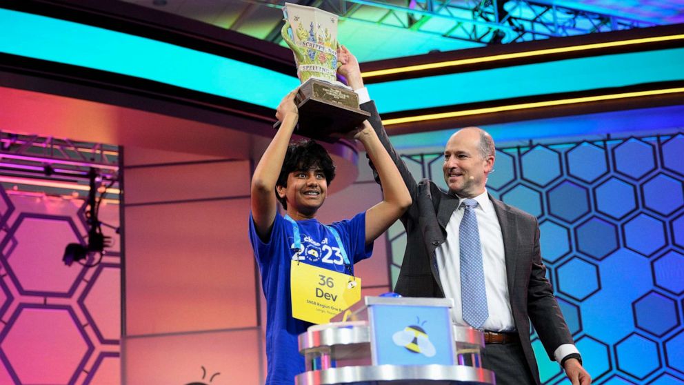 PHOTO: Dev Shah, 14, from Largo, Fla., lifts the trophy next to Scripps CEO Adam Symson after he won the Scripps National Spelling Bee, on June 1, 2023, in Oxon Hill, Md.