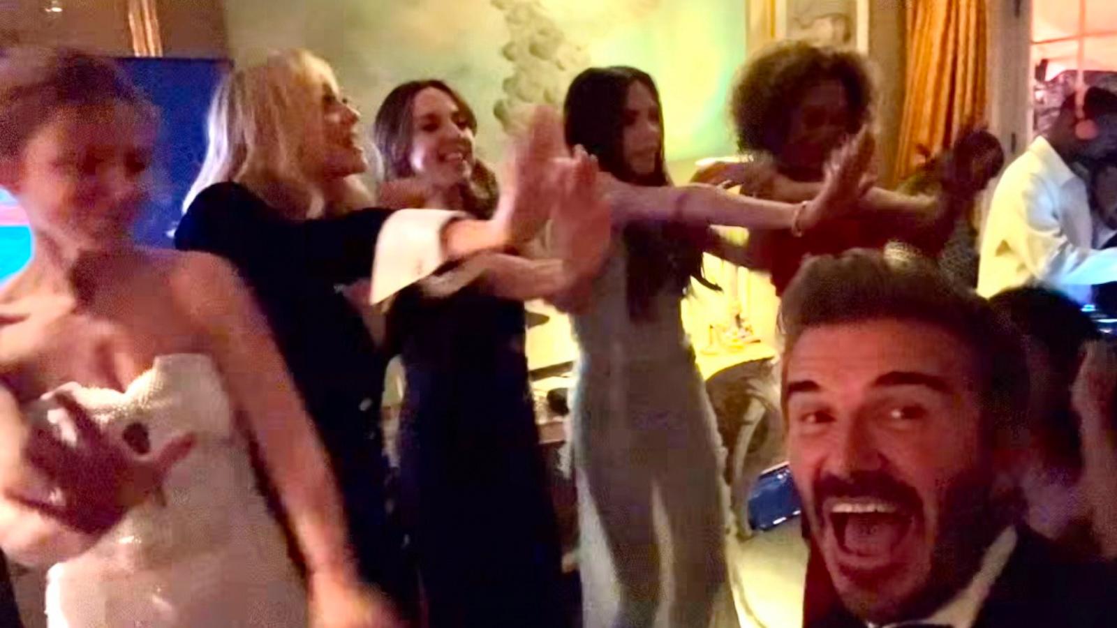 PHOTO: David Beckham watches the Spice Girls perform at Victoria Beckham's 50th birthday.