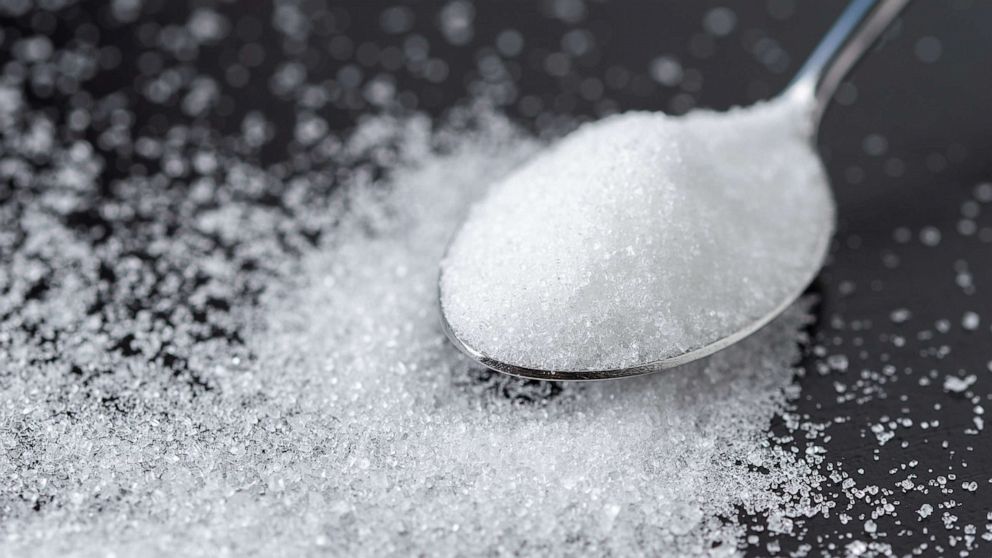 PHOTO: Close-up of a spoon with sugar on a table.