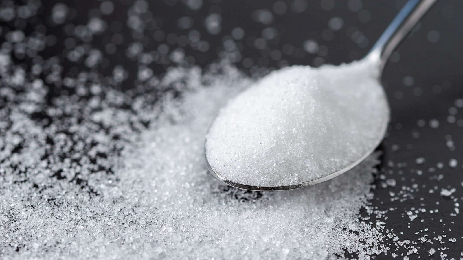 PHOTO: Close-up of a spoon with sugar on a table.