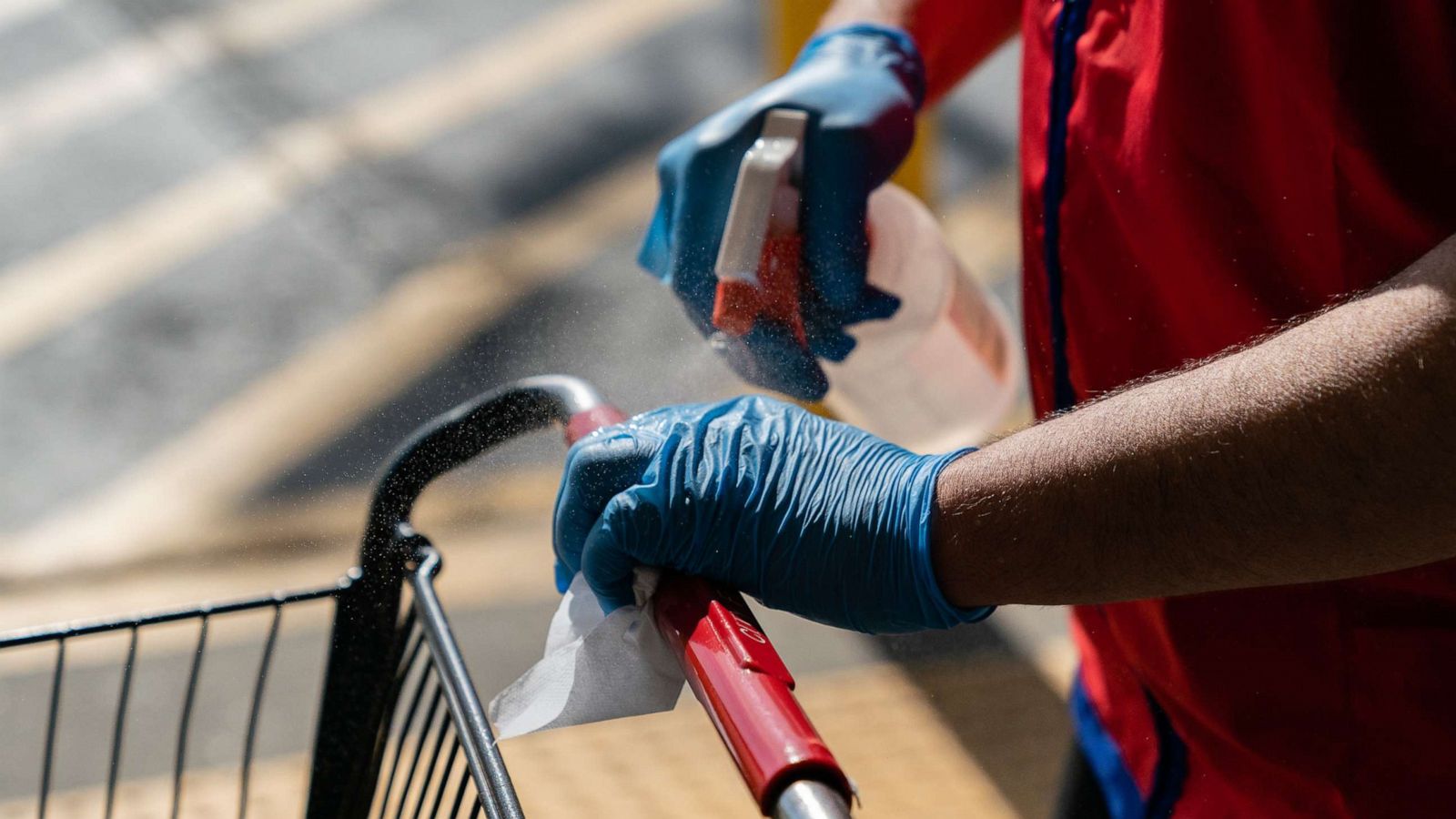 PHOTO: A worker sprays disinfectant on a shopping cart at a City Farmers Market supermarket in Duluth, Georgia, March 26, 2020.