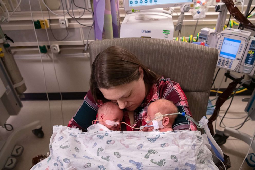 PHOTO: A woman sits with one of 12 sets of twins that are being cared for at Saint Luke's Hospital in Kansas City, Mo.