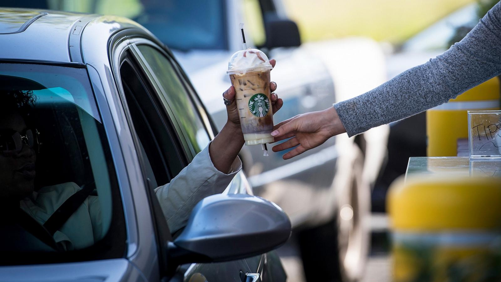 PHOTO: In this April 23, 2018, file photo, an employee passes a drink order to a customer at the drive-thru of a Starbucks coffee shop in Rodeo, Calif.