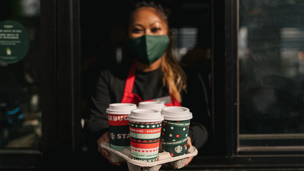 PHOTO: A Starbucks employee holds a tray of holiday drinks.