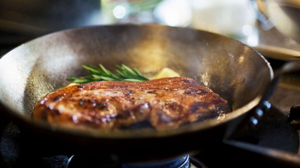 PHOTO: Steak cooking in a skillet with butter and herbs.