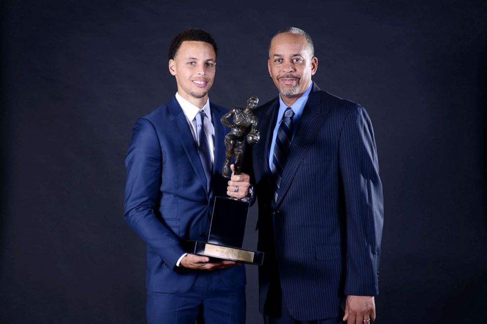 PHOTO: Stephen Curry #30 of the Golden State Warriors poses for a portrait with the Maurice Podoloff Trophy alongside father Dell Curry at the 2014-15 KIA Most Valuable Player Award Press Conference, May 4, 2015, at Oakland, Calif.