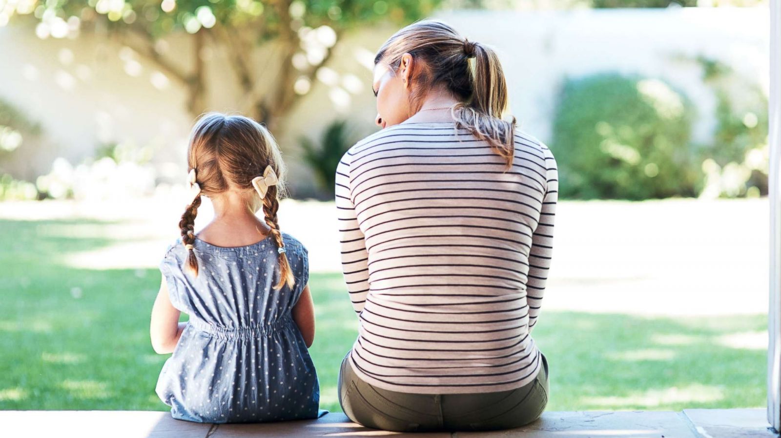 PHOTO: Stock photo of a young girl and an adult woman sitting on a porch talking.