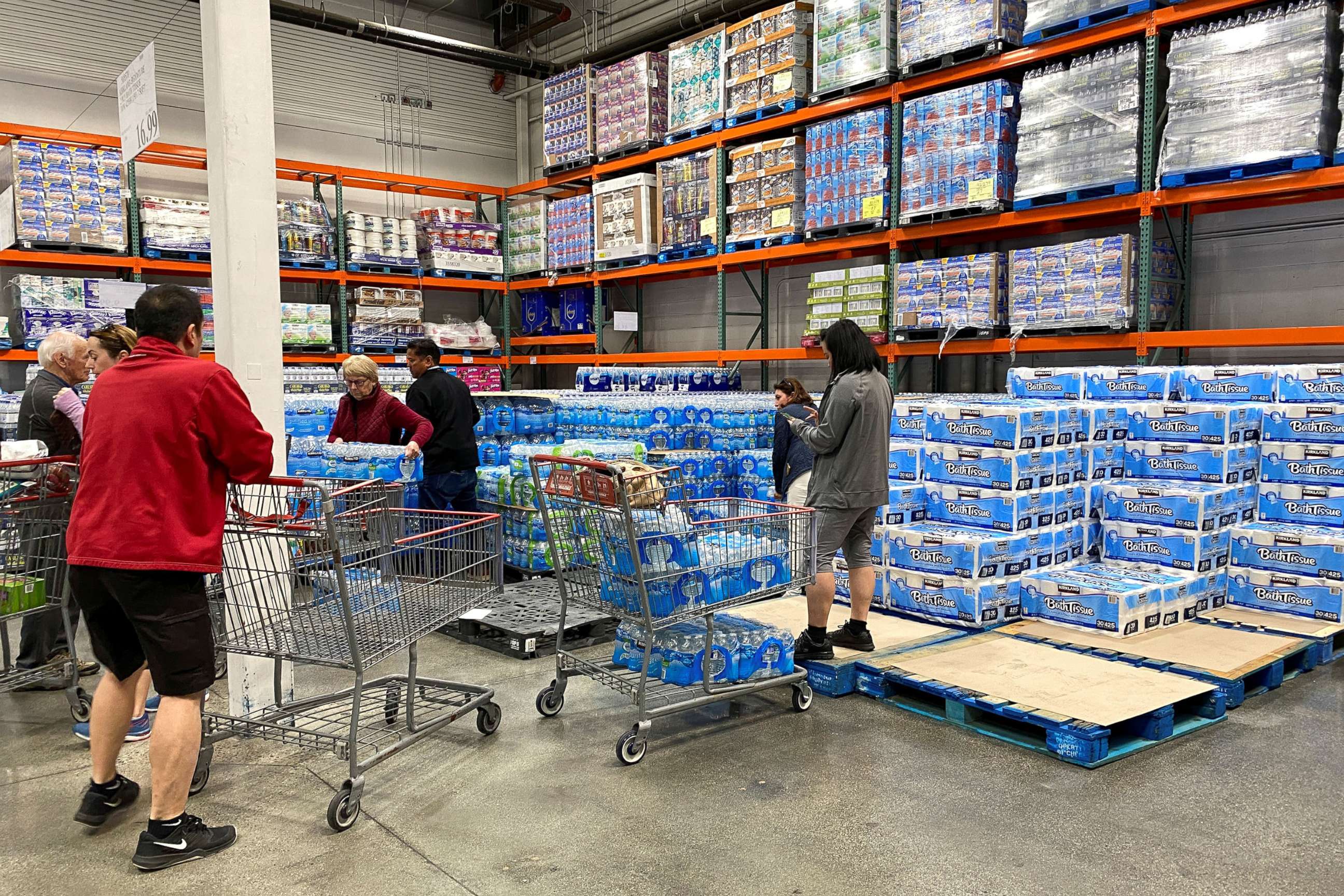 PHOTO: Customers load shopping carts with toilet paper and water at a Costco store in Carlsbad, Calif., March 2, 2020.