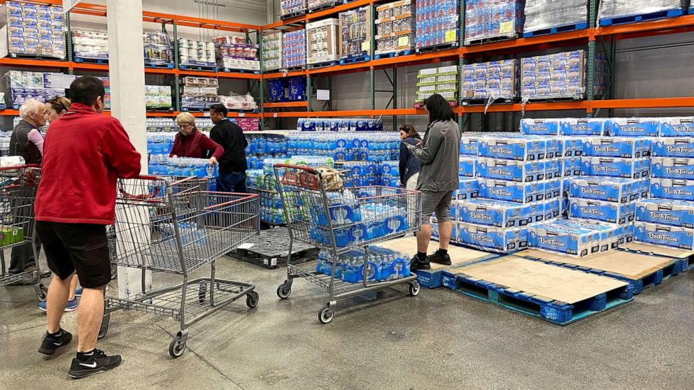 PHOTO: Customers load shopping carts with toilet paper and water at a Costco store in Carlsbad, Calif., March 2, 2020.