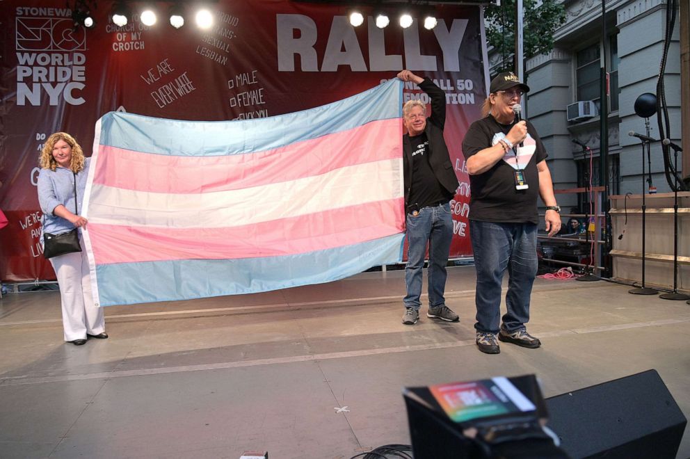 PHOTO: Co-owners of the Stonewall Inn Stacy Lentz and Kurt Kelly are gifted the transgender pride flag from Monica Helms during the Stonewall 50th Commemoration rally during WorldPride NYC 2019, June 28, 2019, in New York.