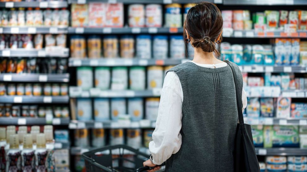 PHOTO: A woman holds a shopping cart in grocery store.