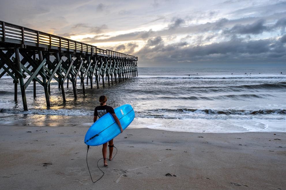 PHOTO: Surfers ride the waves as the ocean is whipped up by Tropical Storm Ophelia at Wrightsville Beach, Sept. 23, 2023, in Wilmington, North Carolina. 