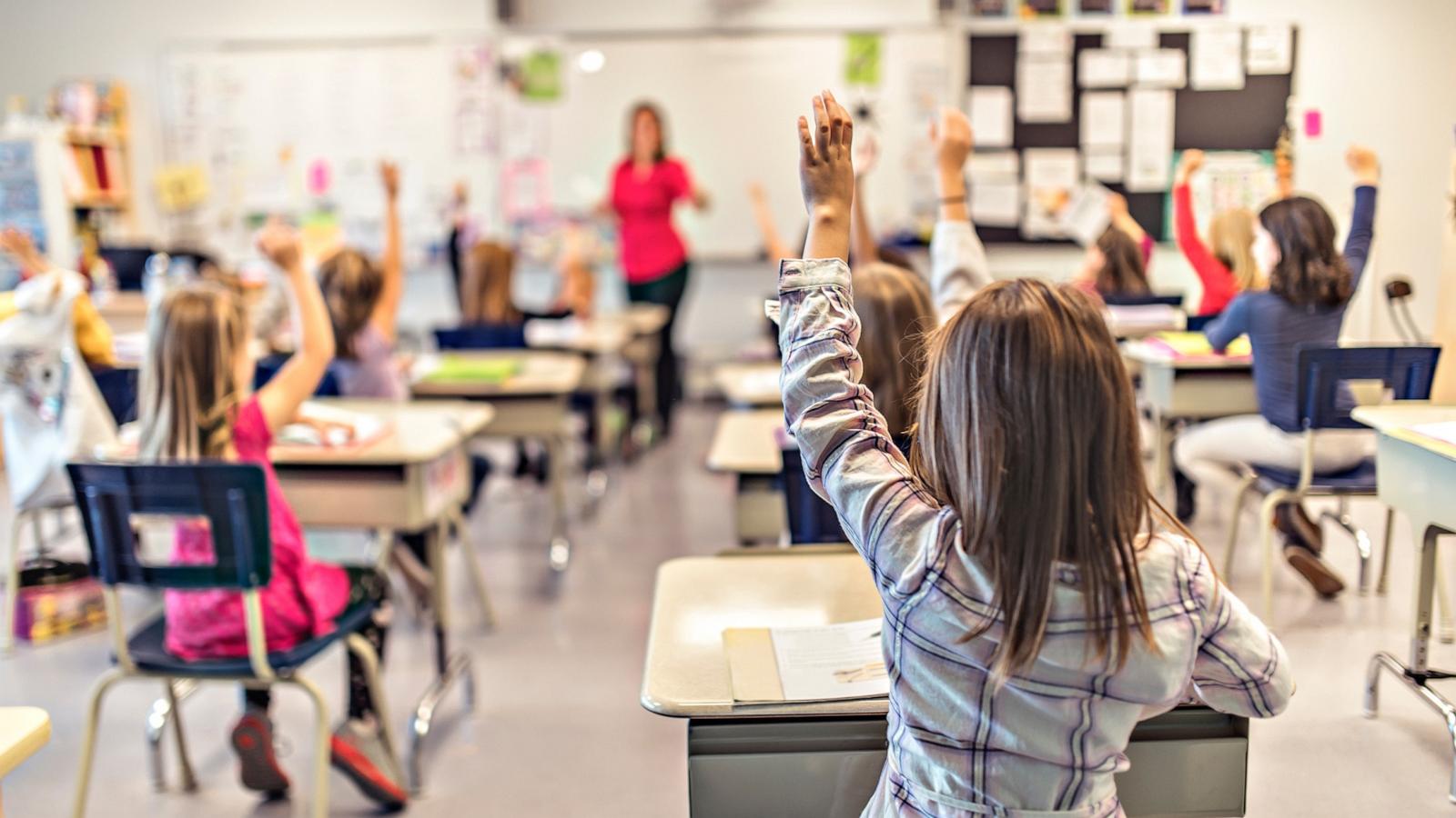 PHOTO: Students raise their hands in a classroom.