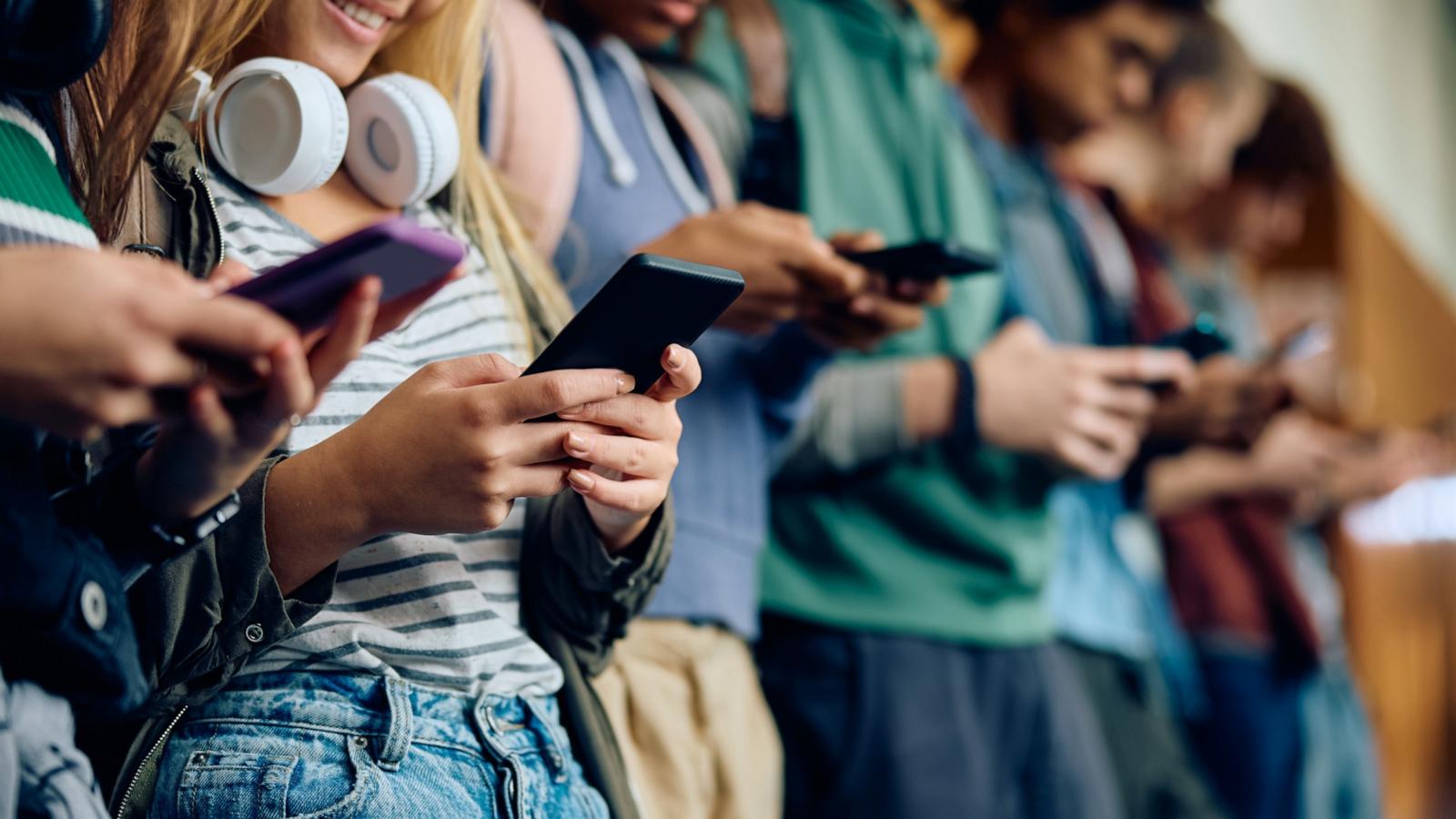 PHOTO: Teenage girl and her friends using mobile phones at high school hallway in this undated stock photo.