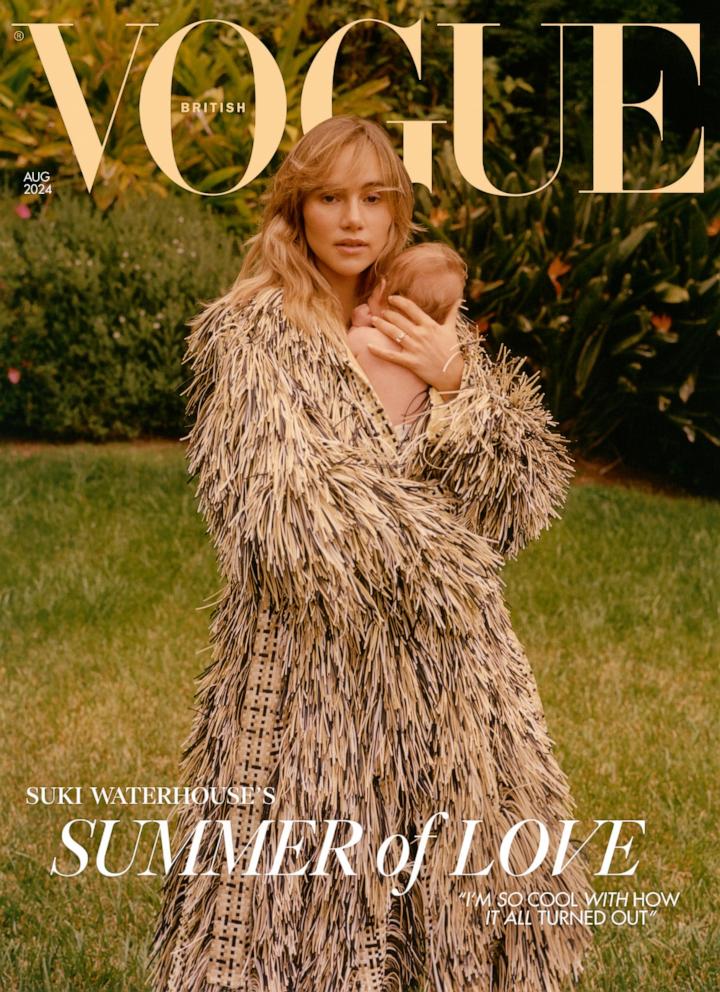 PHOTO: Image shows Suki Waterhouse standing in a lush green garden in the sunshine, holding her baby daughter close to her chest. 