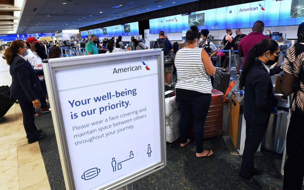 PHOTO: Travelers wait in line at the American Airlines ticket counter at Orlando International Airport, Fla., April 30, 2021.