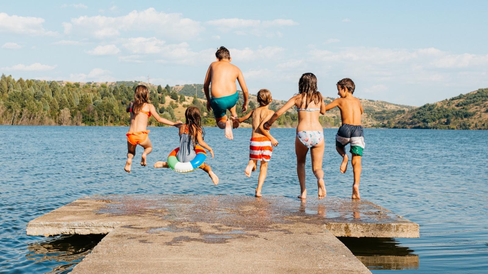 PHOTO: In this undated stock photo, a group of children are seen jumping into a lake on a summer day.