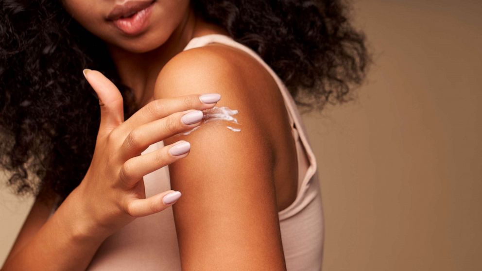 STOCK PHOTO: A woman applying moisturizing cream on shoulder