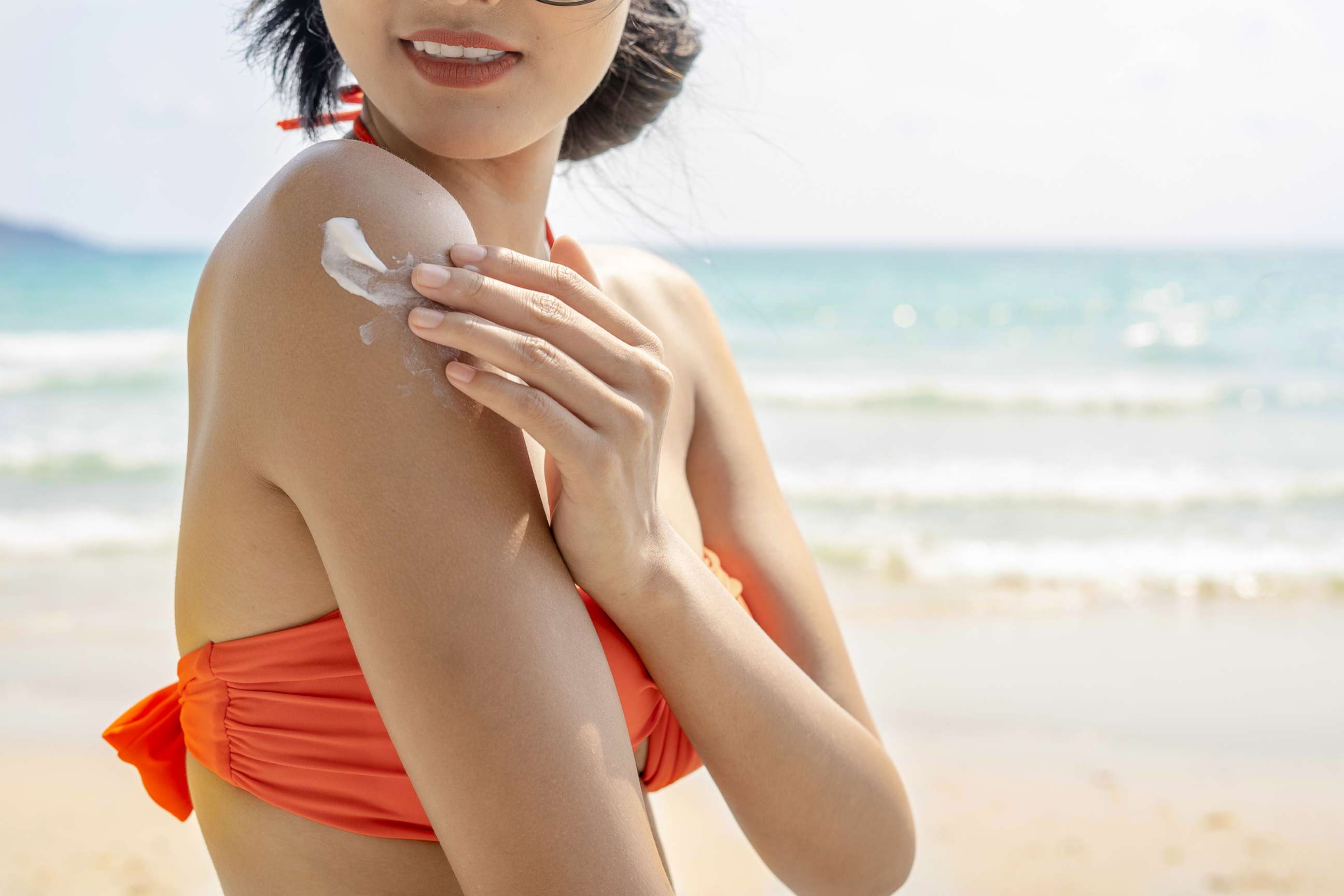 PHOTO: A woman applies sunscreen at the beach.