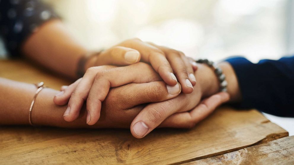 PHOTO: An undated stock photo depicts two people holding hands in comfort.