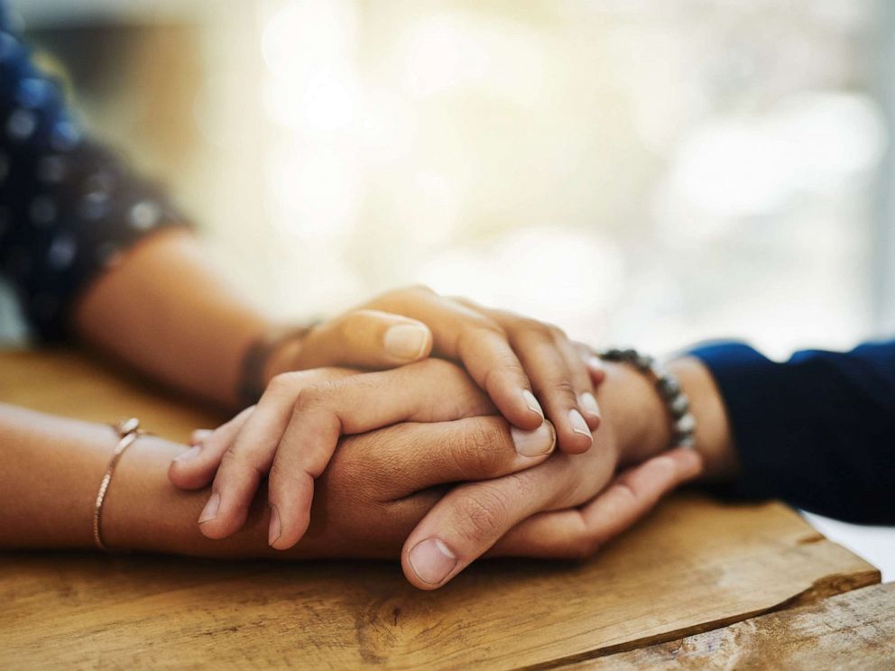 PHOTO: An undated stock photo depicts two people holding hands in comfort.