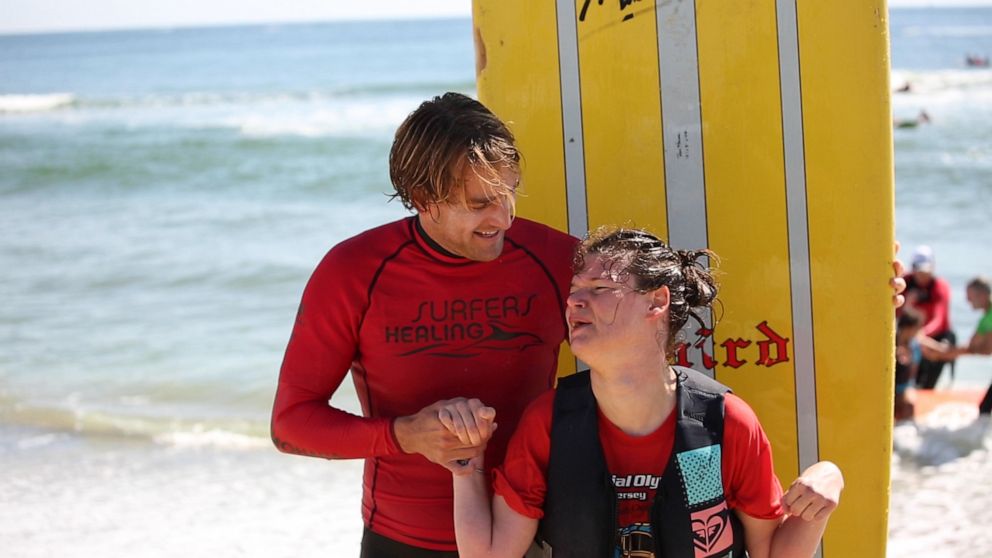 PHOTO: Bethy De Tata who has Cerebral Palsy poses with her surf instructor at Surfers Healing Autism Beach Bash in Belmar, New Jersey.