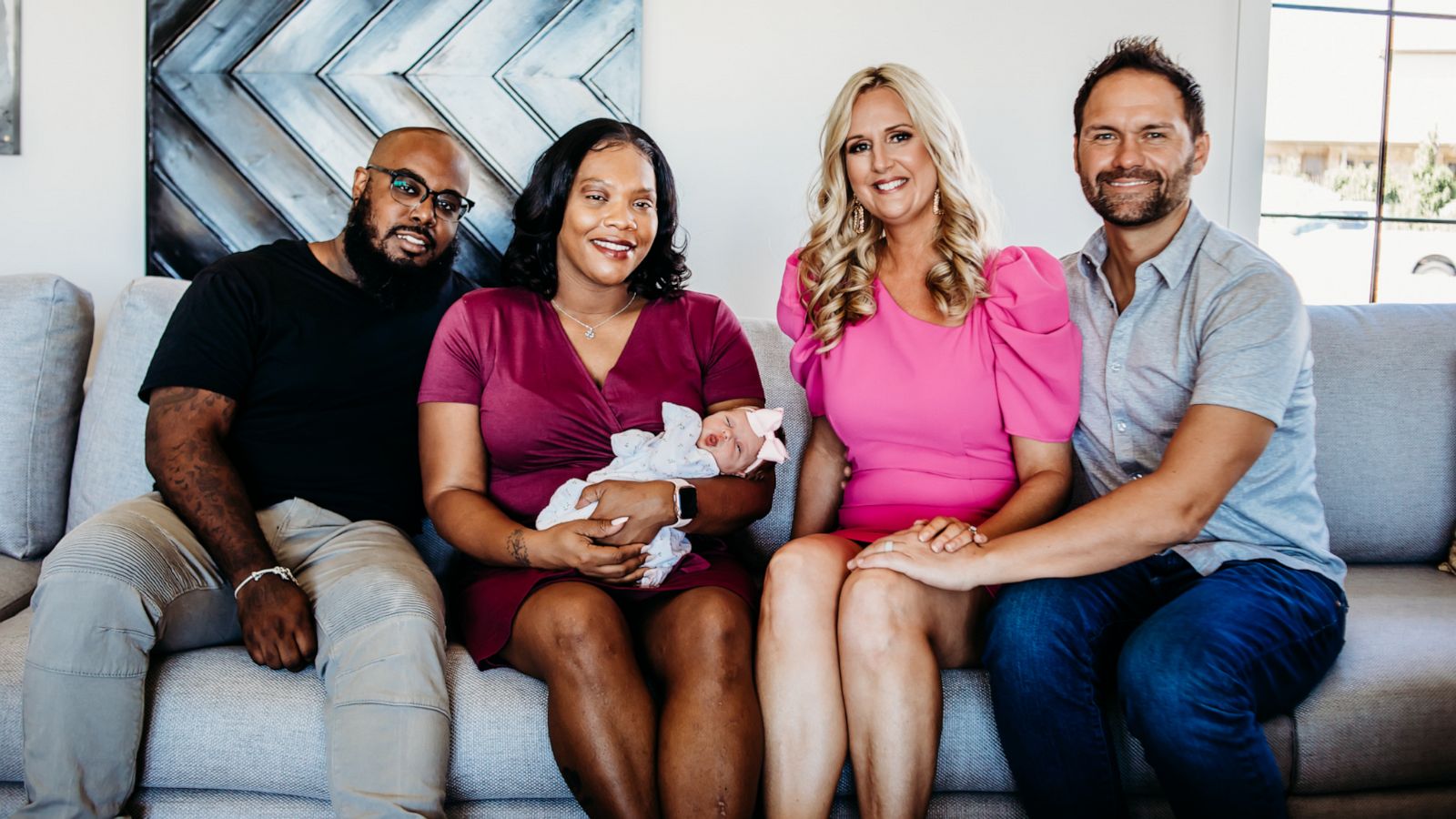 PHOTO: Jasmine Johnson Isaac (second from left), who became a gestational carrier for Kelly and Kyle Savant (right) holds baby Ainsley Savant. Here they are pictured with Isaac's husband, Maurice Isaac (left), as well.