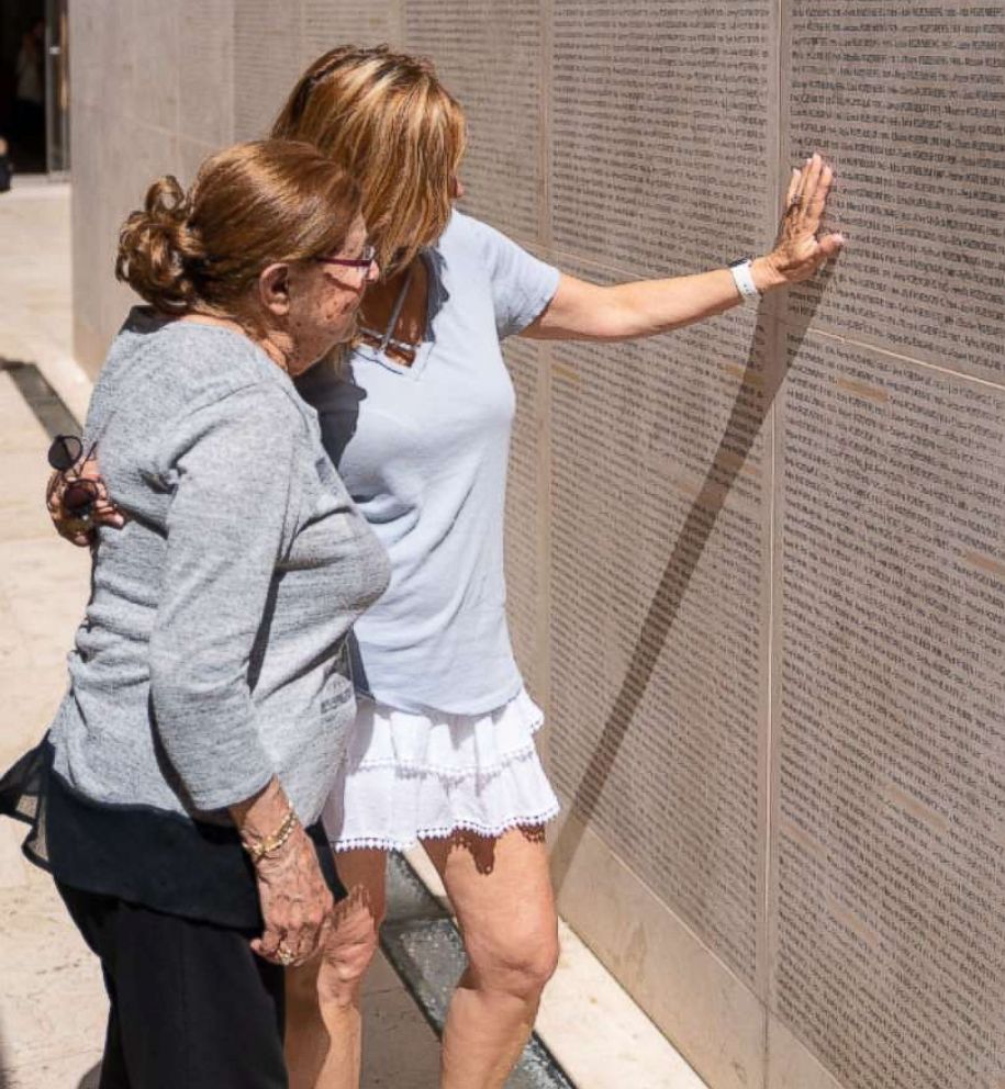 PHOTO: Charlotte and a family member search for Charlotte's parents on Paris's Wall of Names.