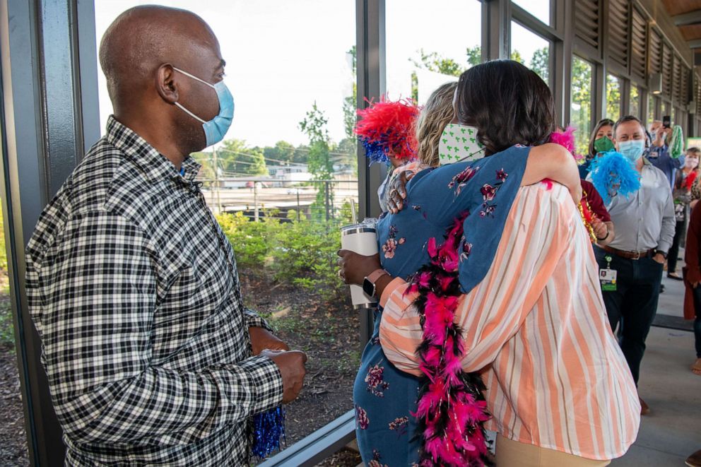 PHOTO: Susan Ellis and Tia Wimbush hug while Rodney Wimbush looks on at Children's Healthcare of Atlanta.