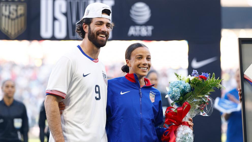 PHOTO: Mallory Swanson #9 of United States and her husband Dansby Swanson embrace prior to the match between USA and Iceland, Oct. 27, 2024, in Nashville, Tenn.
