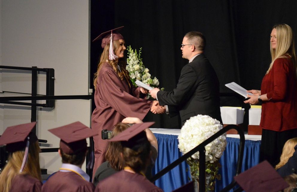 PHOTO: Sydney Helgeson walks across the stage to receive her diploma.