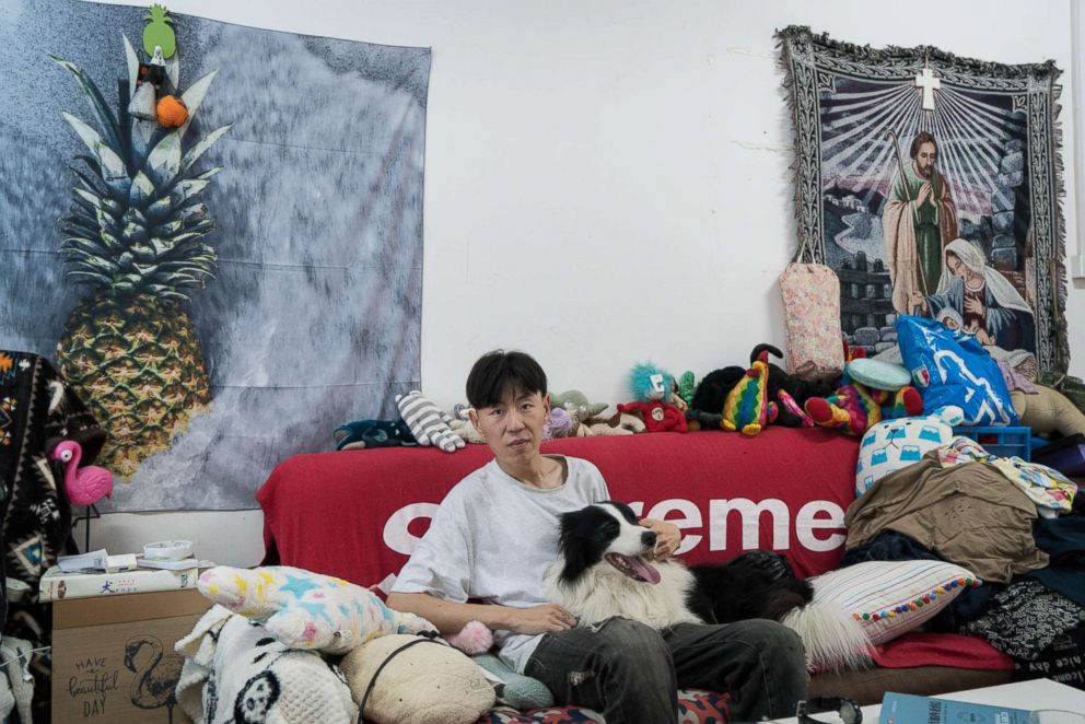 PHOTO: Zhou Tianxiao, 31, sits in the couch in his bedroom posing with his dog, Sylar, a four-year-and-half-old shepherd, in Beijing, July 18, 2018.