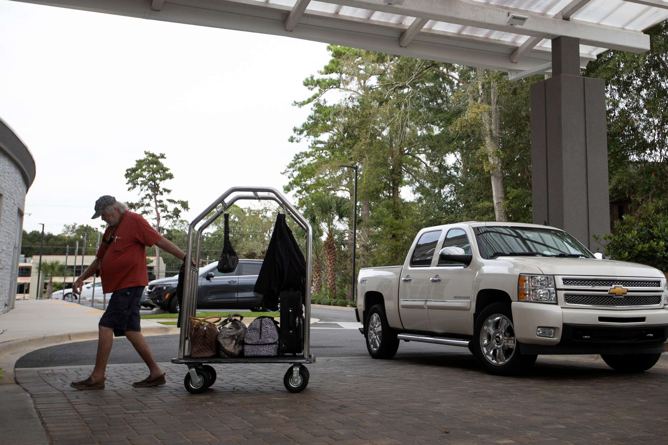 PHOTO: A man brings his belongings into the Holiday Inn Tallahassee East Capital on  Sept. 27, 2022, after evacuating the Tampa area in anticipation of Hurricane Ian.