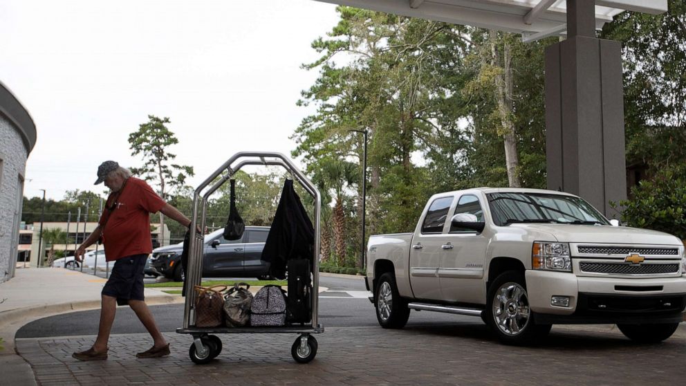 PHOTO: A man brings his belongings into the Holiday Inn Tallahassee East Capital on Sept. 27, 2022, after evacuating the Tampa area in anticipation of Hurricane Ian.