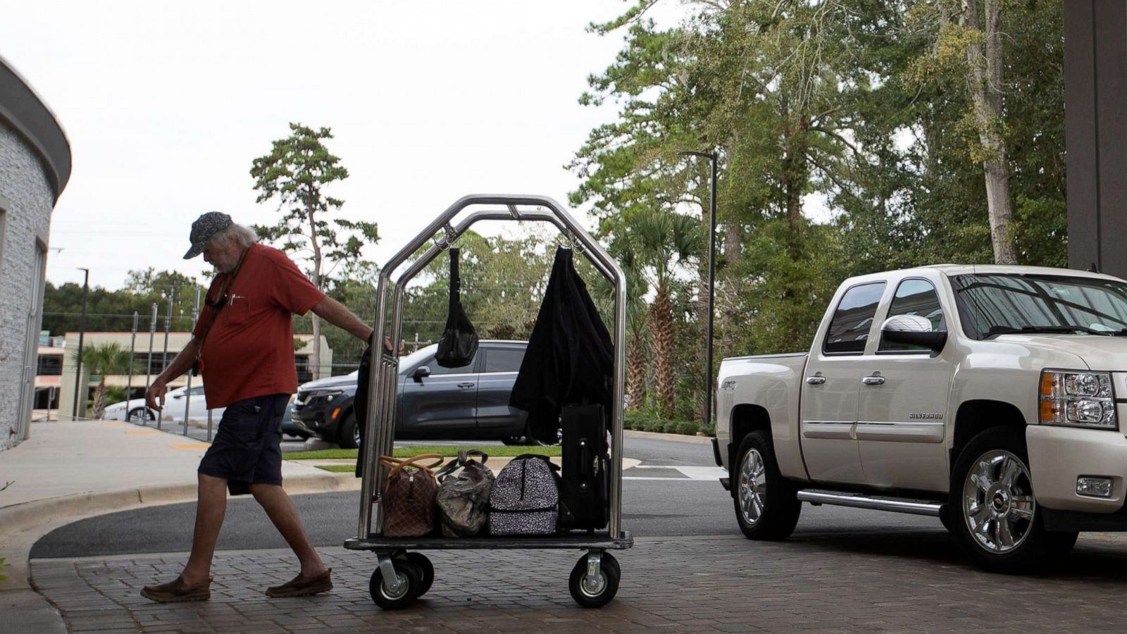 PHOTO: A man brings his belongings into the Holiday Inn Tallahassee East Capital on Sept. 27, 2022, after evacuating the Tampa area in anticipation of Hurricane Ian.