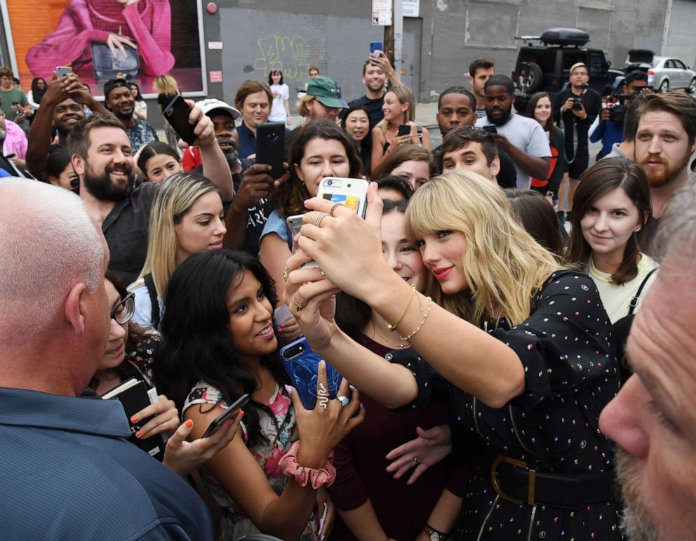 PHOTO: Taylor Swift poses with fans at the Spotify Mural on Album Release Day on August 23, 2019, in Brooklyn, New York.)