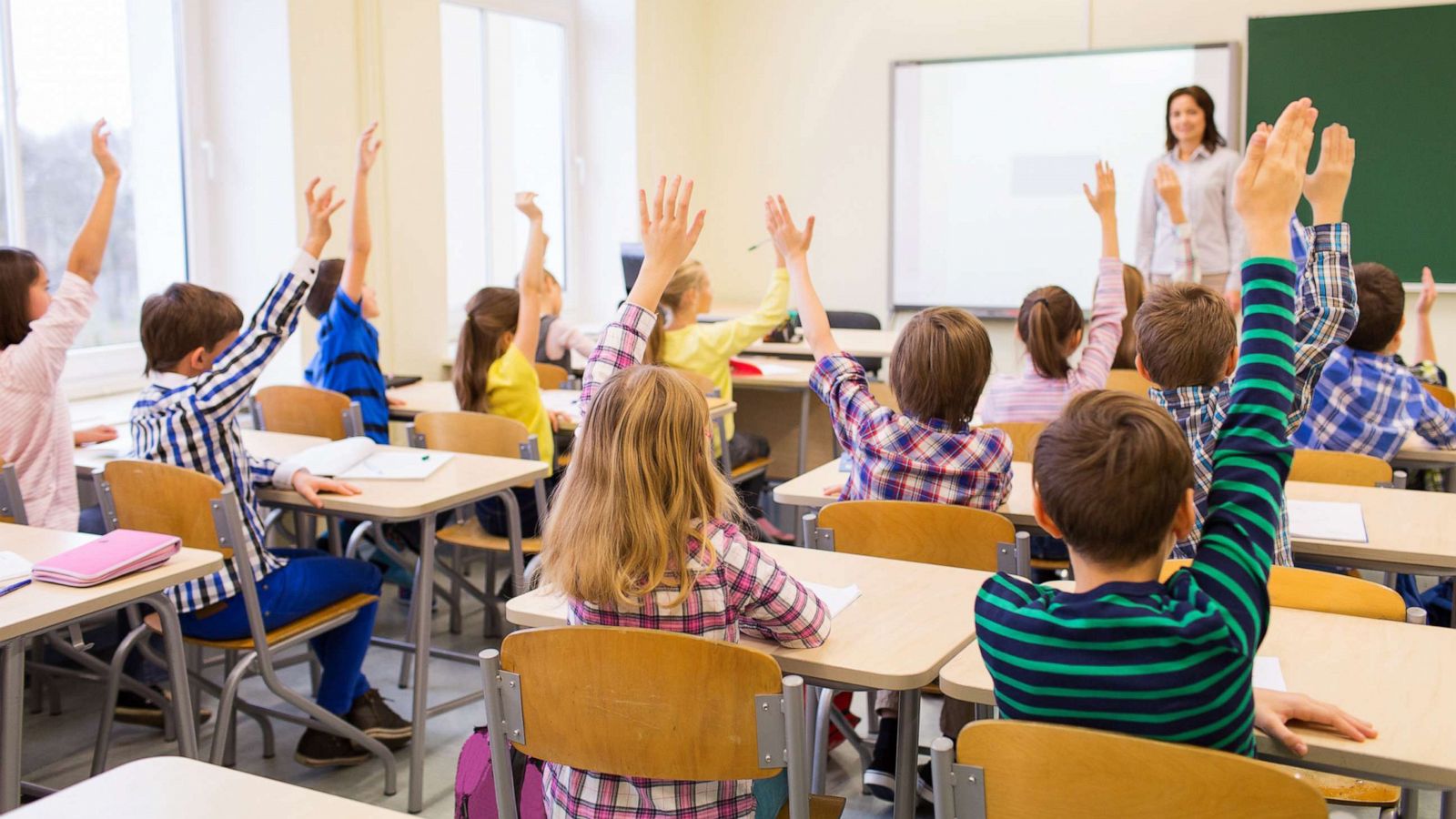 PHOTO: A classroom of students raise their hands for the teacher in an undated stock image.