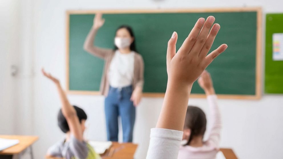 PHOTO: A teacher has a mask on in a stock photo of a classroom. 