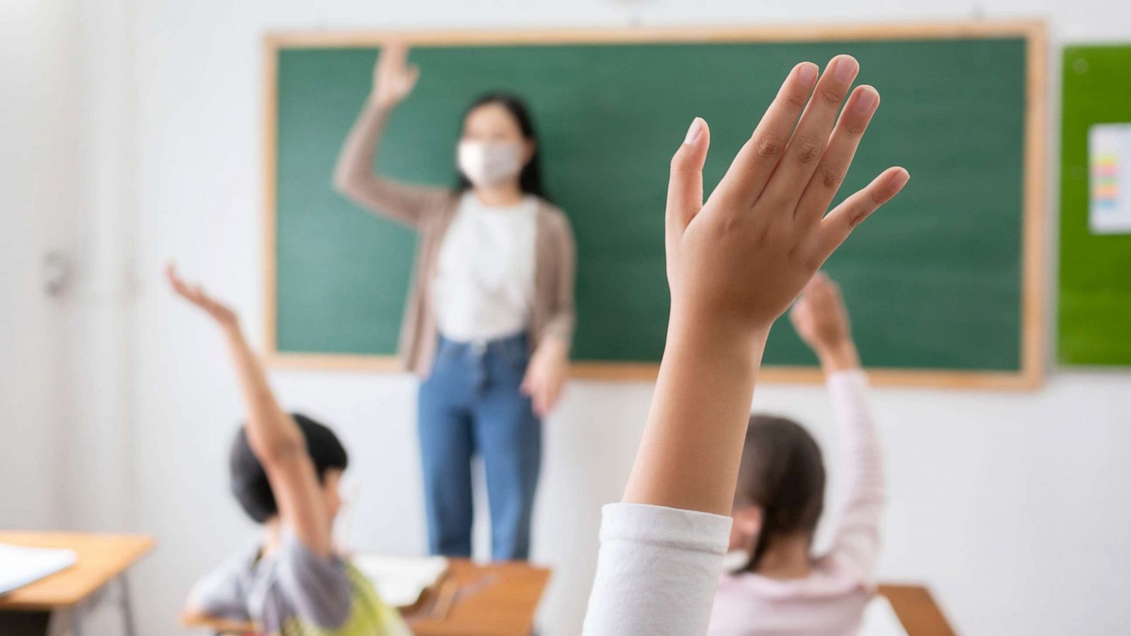 PHOTO: A teacher has a mask on in a stock photo of a classroom.