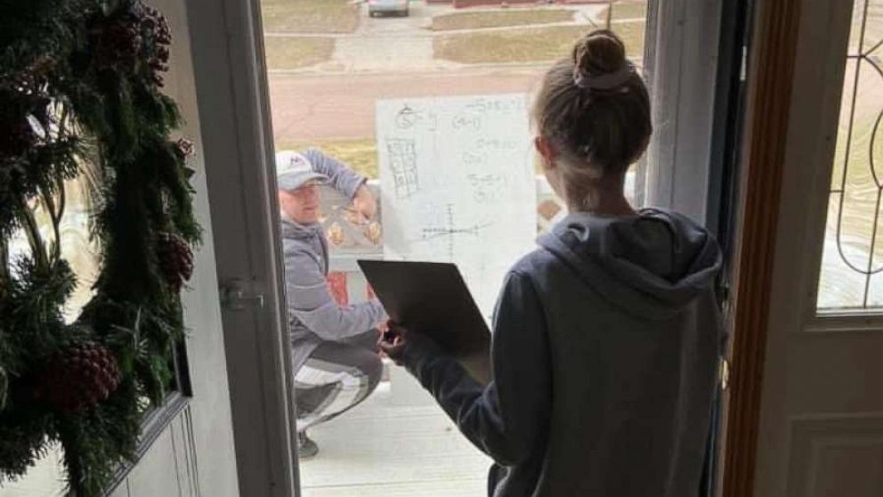 PHOTO: Chris Waba, a middle school math teacher, helps student Rylee Anderson, 12, with her homework in Madison, South Dakota.
