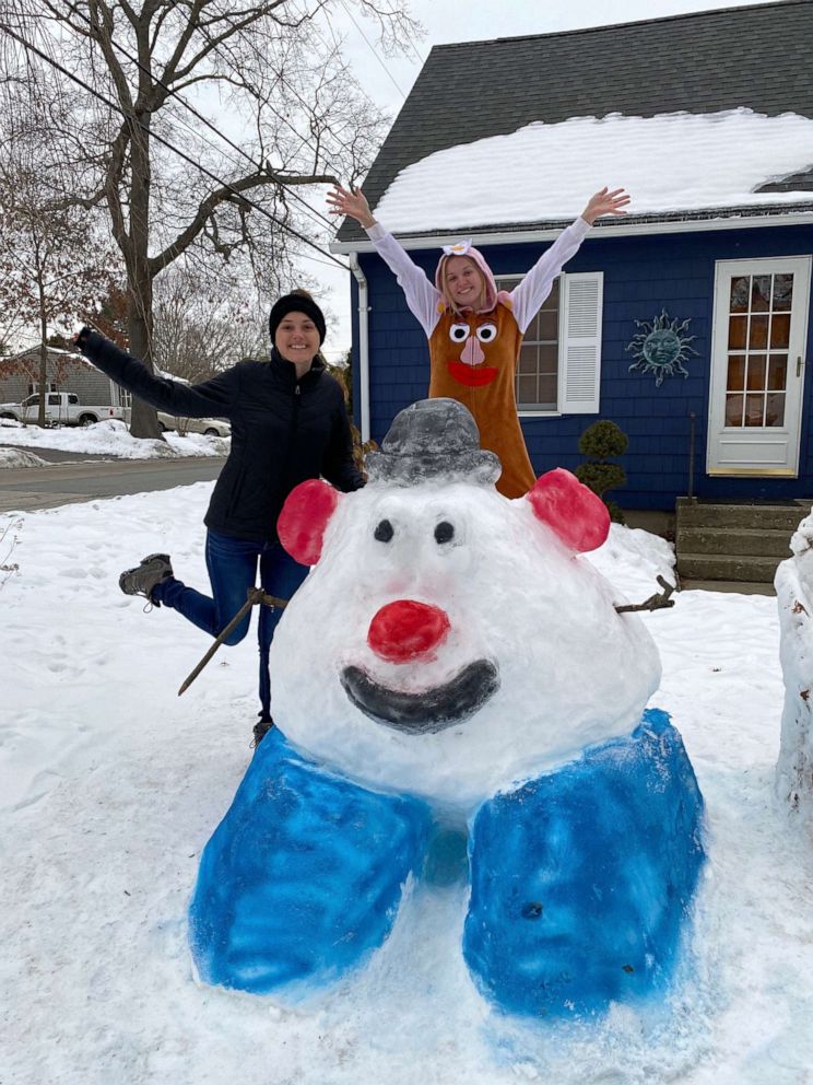 PHOTO: Katina Gustafson of East Providence, Rhode Island, stands in front of a Mr. Potato Head sculpture she made out of snow to inspire her students to go outside and play.