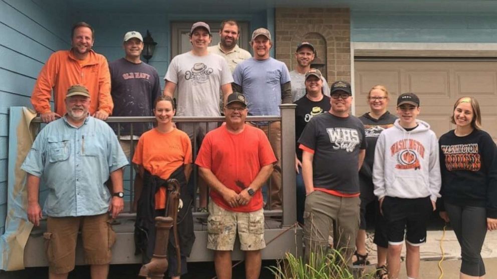 PHOTO: For 22 years, Tim Gjoraas (front row, black shirt) taught anatomy and physiology at Washington High School in Sioux Falls. The 45-year-old father of three was diagnosed with colon cancer last year and friends stepped in to help him paint his home. 
