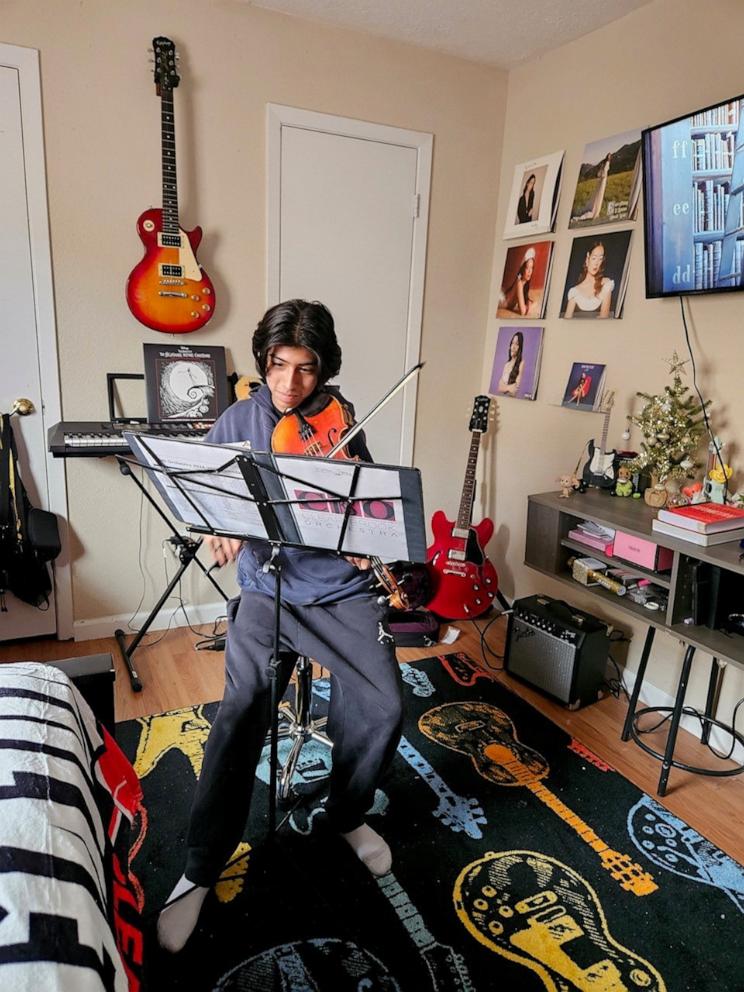 PHOTO: Four months after his heart surgery, Matthew is now back to playing both the guitar and viola at home.