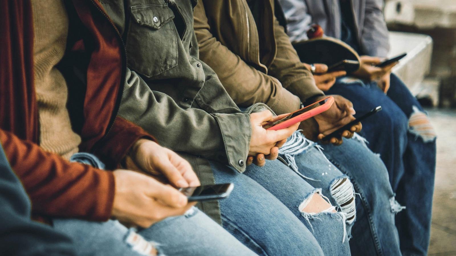 PHOTO: Young people using their mobile phones.