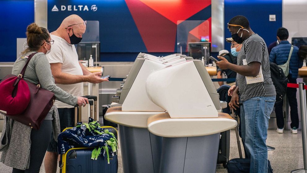 PHOTO: People check-in at a Delta station for departure flights at the George Bush Intercontinental Airport on Jan. 13, 2022, in Houston.
