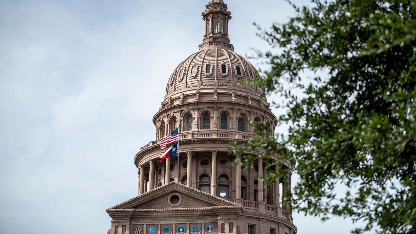 PHOTO: In this July 12, 2021, file photo, the U.S. and Texas state flags fly outside the state Capitol building in Austin, Texas.