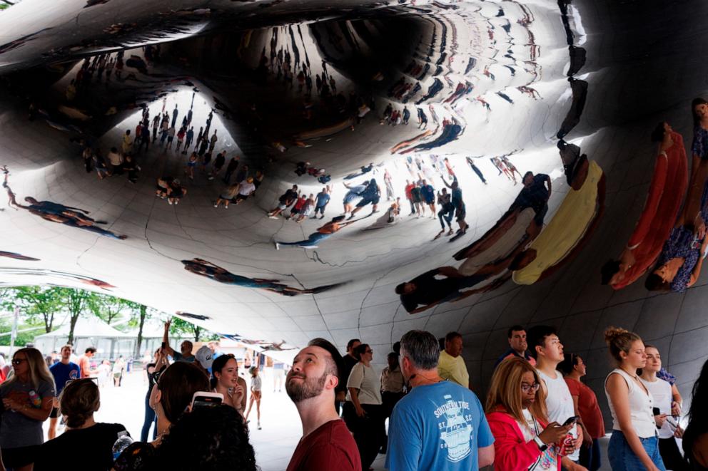 PHOTO: Visitors look up and take photos of the underside of the "Cloud Gate" sculpture, also known as the "bean," at Millennium Park, June 23, 2024.